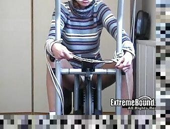 Hot athletic Russian girl tied to the bicycle in the gym