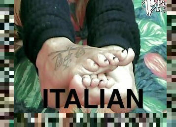 Adorable Italian babe rubbing her tattooed feet with oil close up