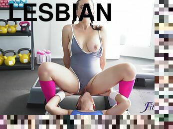 Playful lesbian girlfriends lick each other on fitness ball
