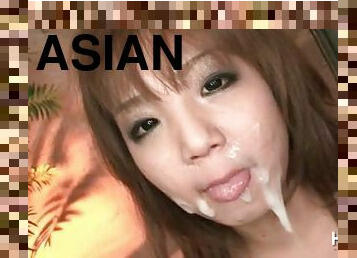 Asian slut blowing two cocks gets a messy facial