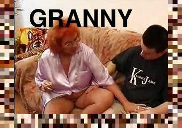 Lewd redhead granny plays with some young guy's hard cock