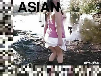 Cute Asian teen dances around the duck filled pond