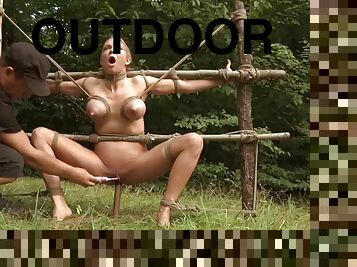 Crucified slaved babe in bondage pussy showcased outdoor