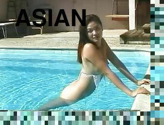 Skimpy bikini on a cute Asian girl modeling in the pool