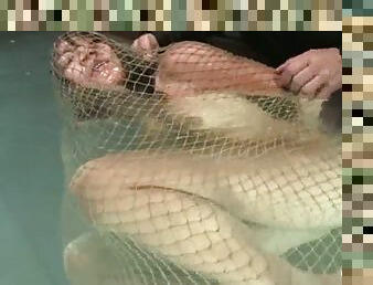 Keeani Lei gets wrapped in the net and thrown in the water