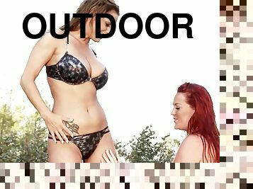 Paige Delight and Sheila Grant get down for some girl on girl hot tub action outdoors