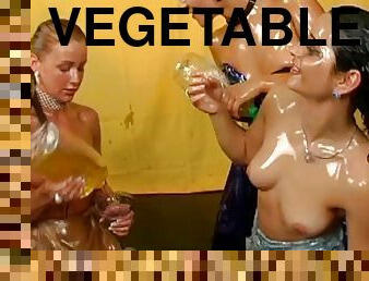 Women in fancy dresses cover each other in vegetable oil