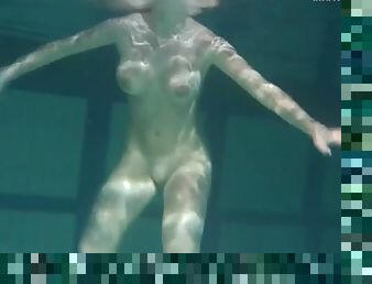 Naked brunette with big tits swims solo