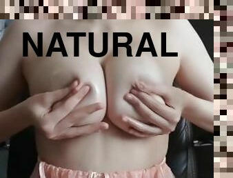 caresses big natural tits and pours oil on them