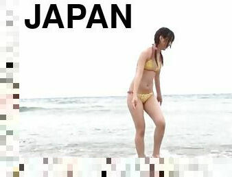 Playful Japanese bikini girl on a sandy beach