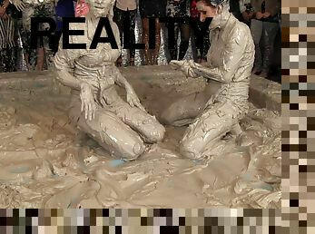 Leather-clad brunette with a sexy body having a catfight in a mudbath