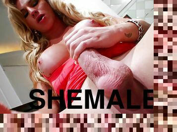 Shemale with fake tits jerks off dick in red dress