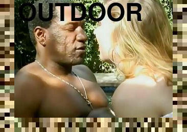 Interracial clip with White chick sucking a dick outdoors