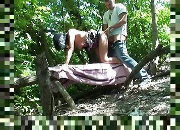 Brunette sucks two dicks in the forest and gets fucked