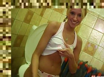 A blonde with pigtails sneaks into the bathroom with her toy