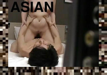 Spy cam in the bedroom films a horny Asian MILF having sex