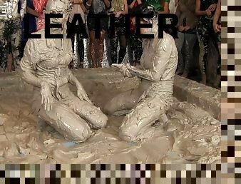 Leather-clad brunette with a sexy body having a catfight in a mudbath