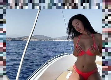 Brunette with big tits masturbates in the open sea on a boat