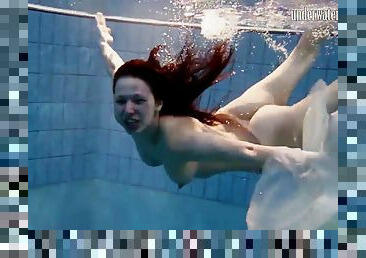 Long hair solo model blonde widening legs while diving in pool