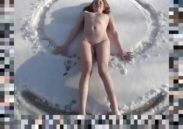 Redhead sits her naked ass in the snow