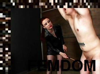 Shackled male slave gets whipped by red haired domina