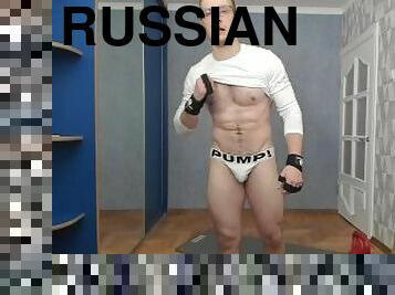 Russian guy lifts a dumbbell in sexy underwear