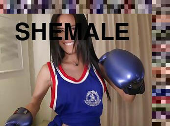 Ladyboy Green is wearing a blue tank top with boxing gloves and ankle supports.