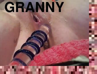 Hot granny pleasures her cunt with a big glass dildo
