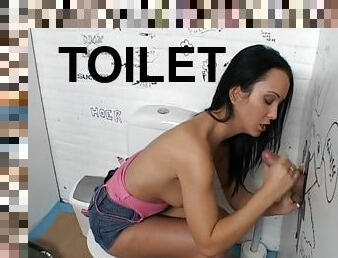 Slut takes a piss and sucks a dick in a gloryhole bathroom