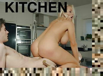 Curvy blonde climbs onto a kitchen table to get a deep fuck
