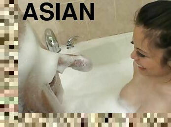 Naughty Asian girl giving a seriously soapy handjob to a white guy