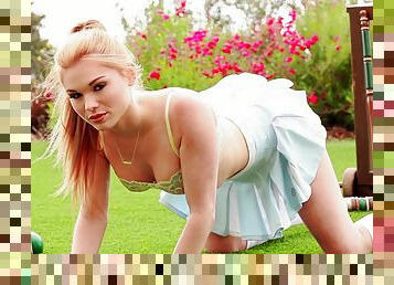 Redhead in a pleated skirt and sexy panties plays in the grass