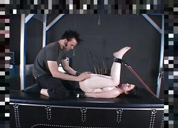 A slave is spanked and tortured by her master in a dungeon