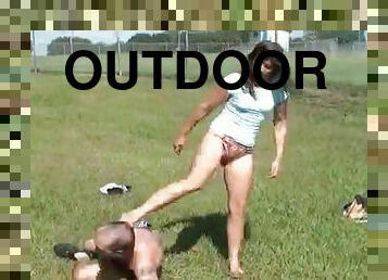 Girl kicks and beats on a guy outdoors