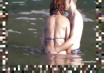 Horny couple having some fun in the water at the beach