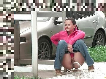 Pretty girl taking a piss on a public street