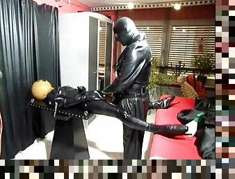 Kinky latex and leather play in dungeon