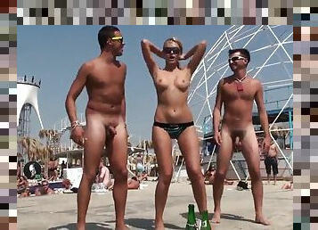 Naked guys on the beach have fun with a young girl