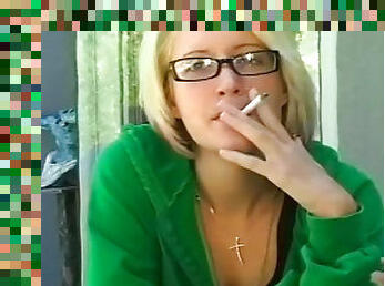 Sexy blonde is smoking a cigarette outdoors
