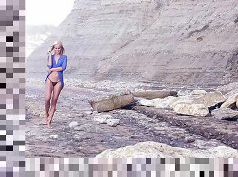 Desirable blonde strips while walking on the deserted beach