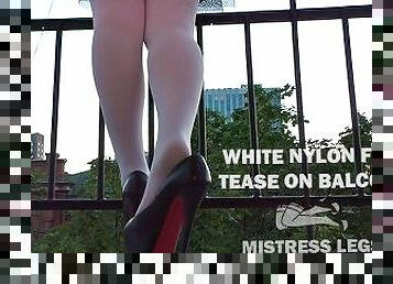Mistress in white pantyhose and high heels foot tease on the balcony