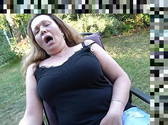 the mature using her fingers to finger her wet pussy in the garden