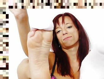 Cute redhead showing her feet and playing with a massive dildo