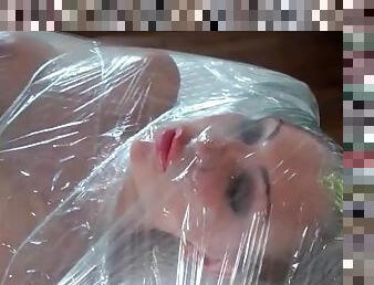Leigh Darby wrapped entirely in plastic