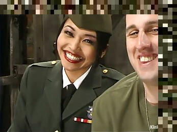 Asian girl in military uniform spanks a guy and sits on his face