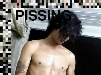 Dashing young man strokes himself while peeing on his body